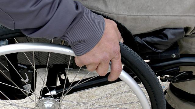 Man with a hand on a wheelchair